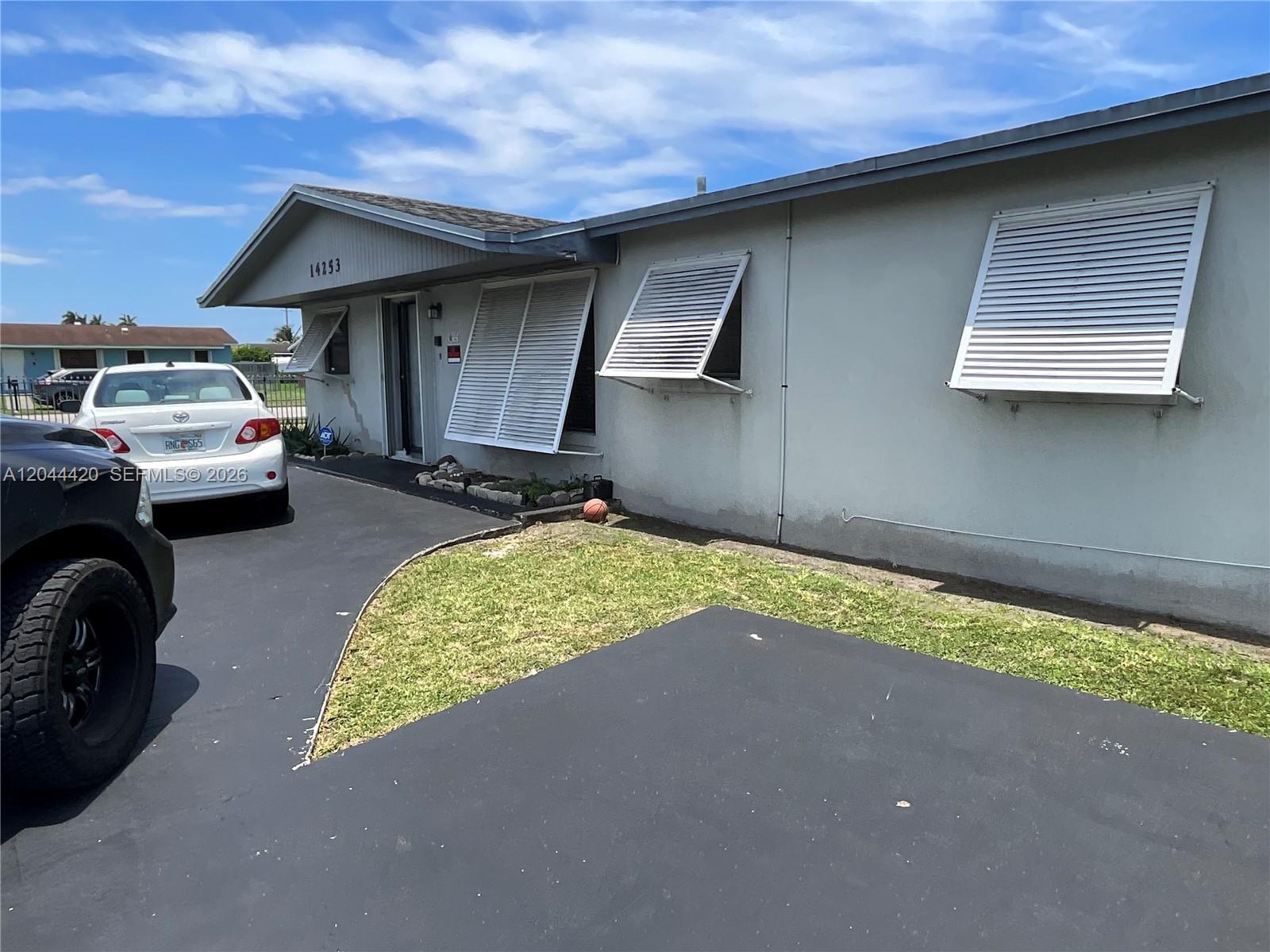 A single-story house with a white exterior, metal shutters, and an asphalt driveway — 14253 SW 107th Pl # X, Miami FL 33176, MIAMI, FL