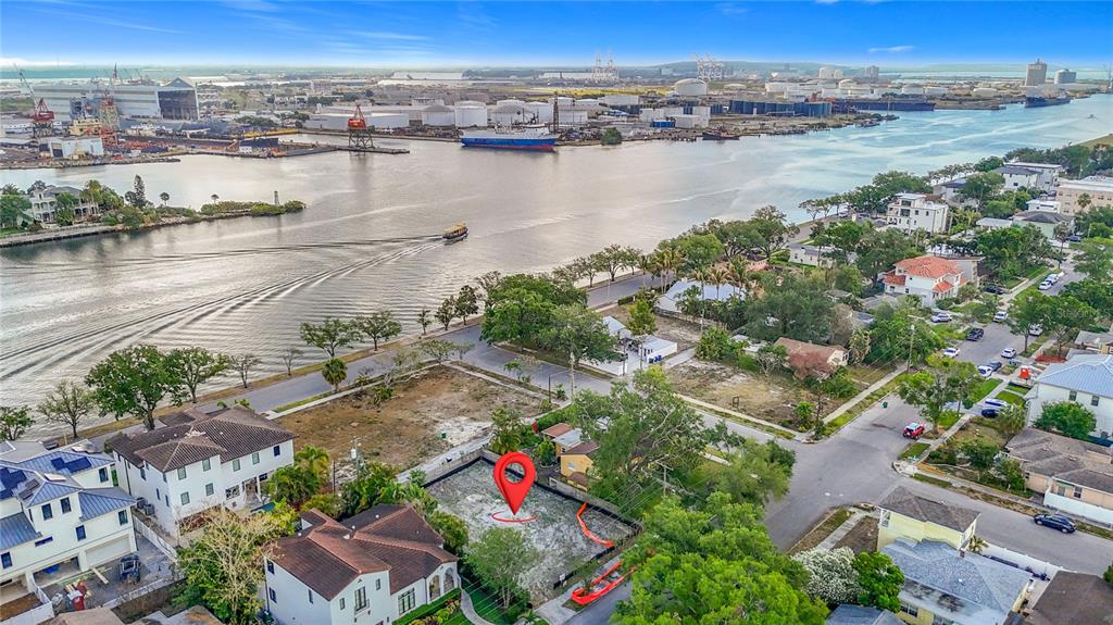 An aerial view shows a vacant waterfront lot marked with a red pin near industrial docks — 329 COLUMBIA DRIVE, TAMPA, FL