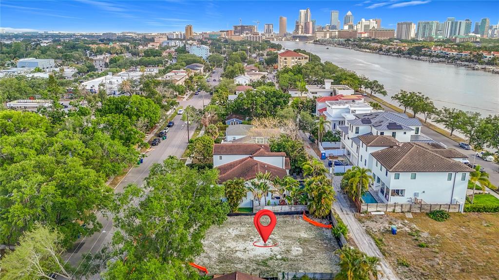 An aerial view shows a vacant residential lot marked with a red pin near water — 329 COLUMBIA DRIVE, TAMPA, FL