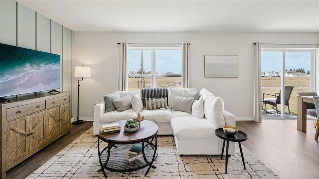 A living room features a white sectional sofa, a wooden media console, and sliding glass doors — 746 GREENWAY BOULEVARD, LAKE WALES, FL