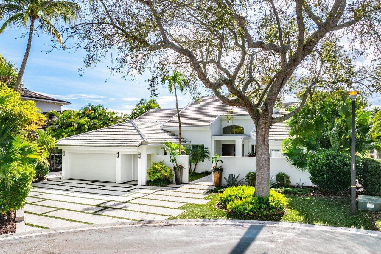 A white single-story house with a tiled roof, a paved driveway, and mature landscaping — 215 Island Drive, Jupiter FL 33477, JUPITER, FL