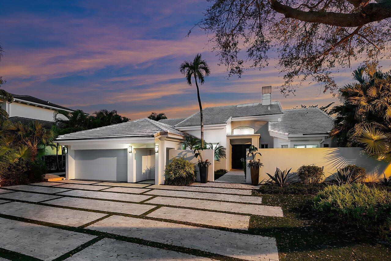 A white house with a tiled roof and a paved driveway at sunset — 215 Island Drive, Jupiter FL 33477, JUPITER, FL