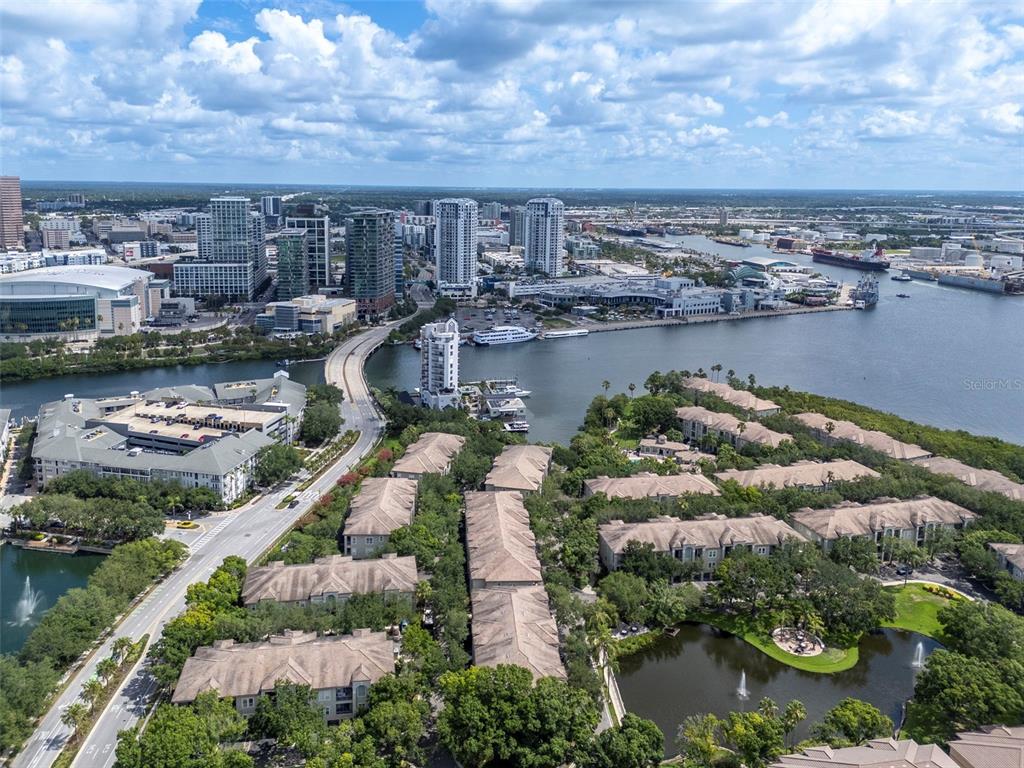 An aerial view shows a residential complex with ponds near a city skyline and waterfront — 450 KNIGHTS RUN AVENUE UNIT 1503, TAMPA, FL