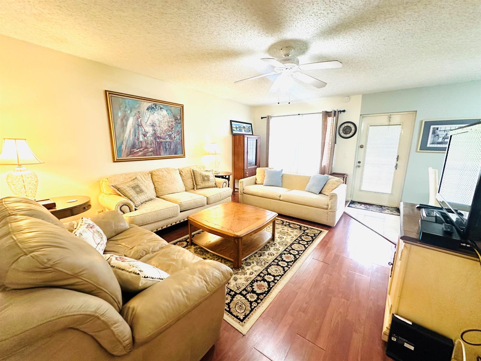 A living room features a beige sofa, a wooden coffee table, and a patterned area rug. k — 174 Durham C, Deerfield Beach FL 33442, DEERFIELD BEACH, FL