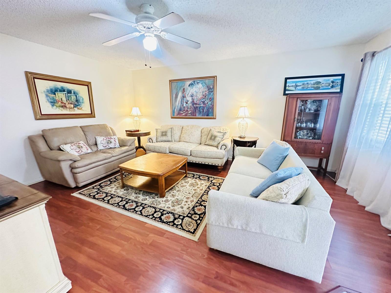 A living room features three sofas, a wooden coffee table, and a ceiling fan — 174 Durham C, Deerfield Beach FL 33442, DEERFIELD BEACH, FL