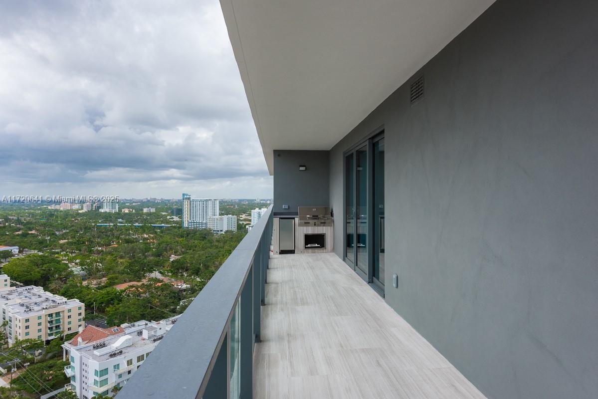 A high-rise balcony features a built-in outdoor kitchen, glass railings, and views of the city — 1451 Brickell Ave # 2103, Miami FL 33131, MIAMI, FL