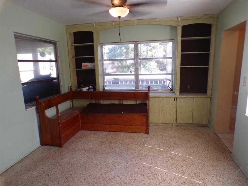 A room features a wooden corner bench, built-in shelving, and a ceiling fan — 5606 87TH AVENUE N, PINELLAS PARK, FL