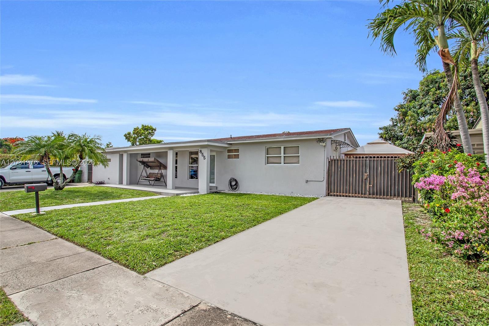 A single-story house with a concrete driveway, a front porch, and a fenced side yard — 855 W 70th Pl, Hialeah FL 33014, HIALEAH, FL