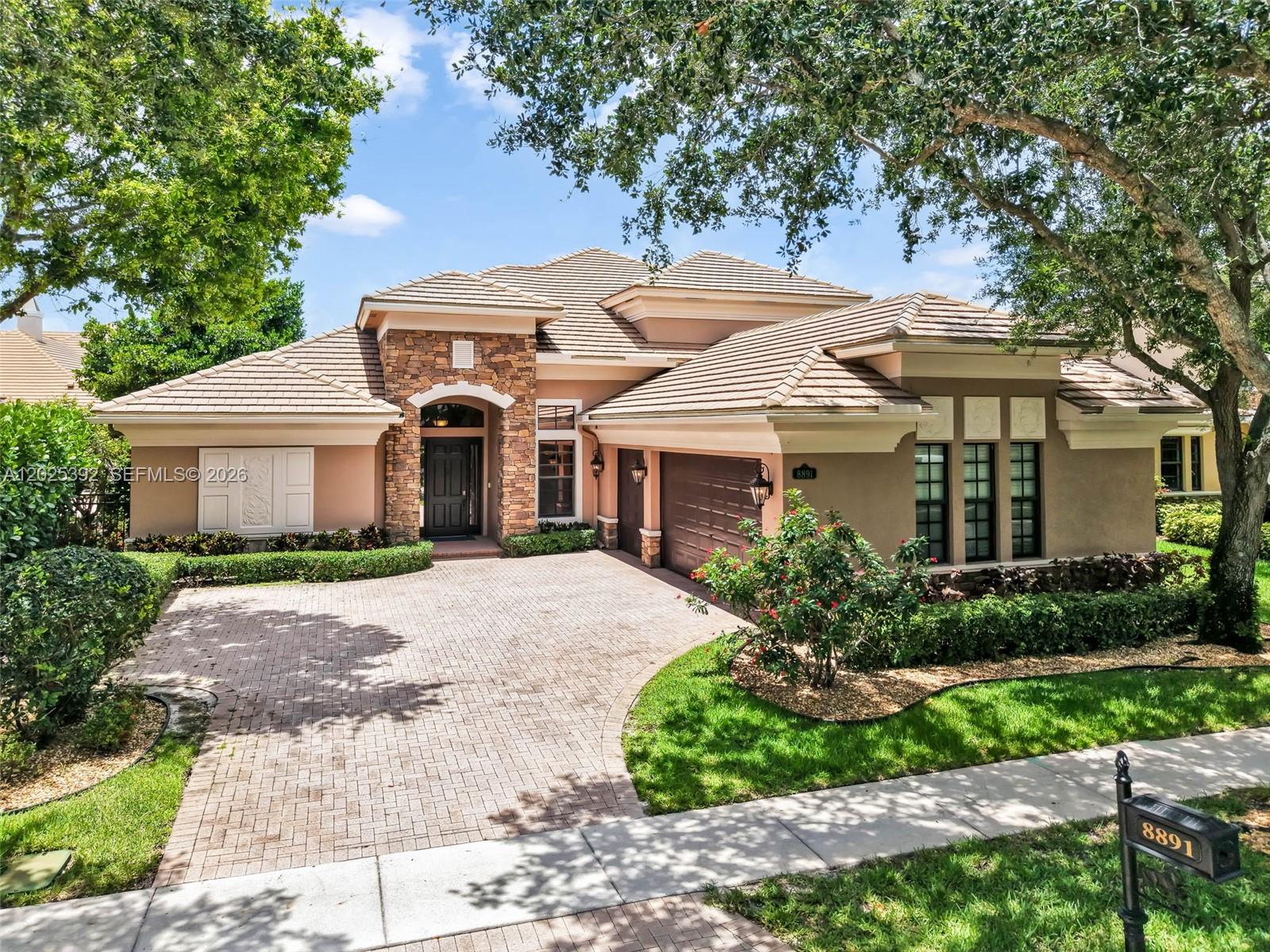 A single-story house with a stone-accented entrance, tiled roof, and a paved driveway — 8891 Equus Cir, Boynton Beach FL 33472, BOYNTON BEACH, FL