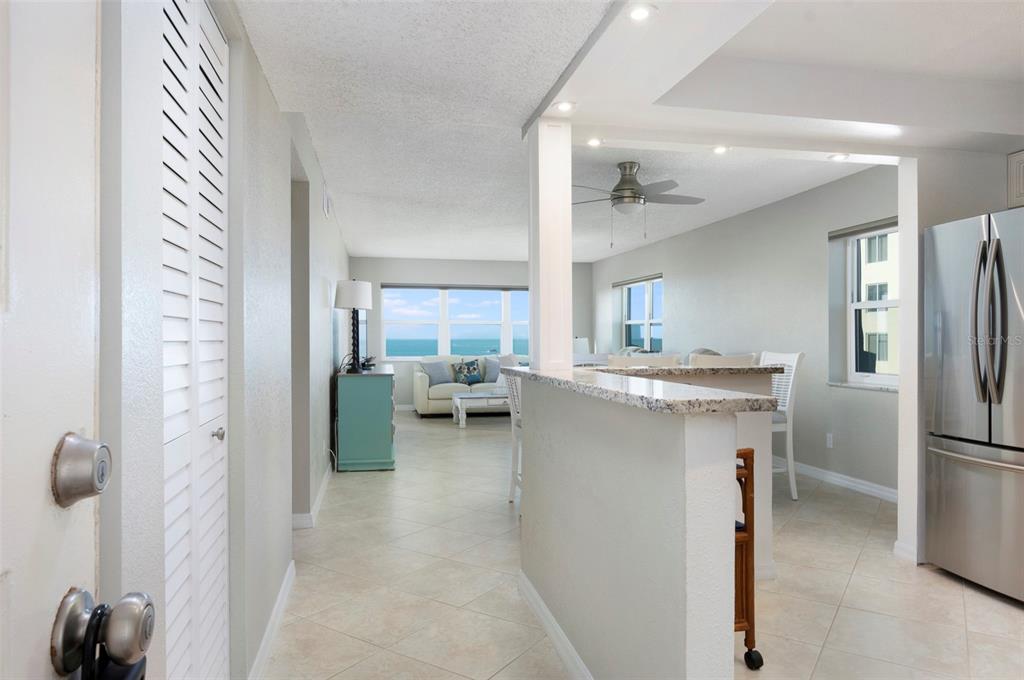 An interior view of a condo entrance looking toward a living area with ocean views — 1230 GULF BOULEVARD UNIT 608, CLEARWATER BEACH, FL