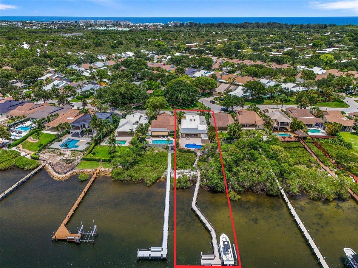 An aerial view shows a waterfront house with a private dock and swimming pool — 352 River Edge Road, Jupiter FL 33477, JUPITER, FL