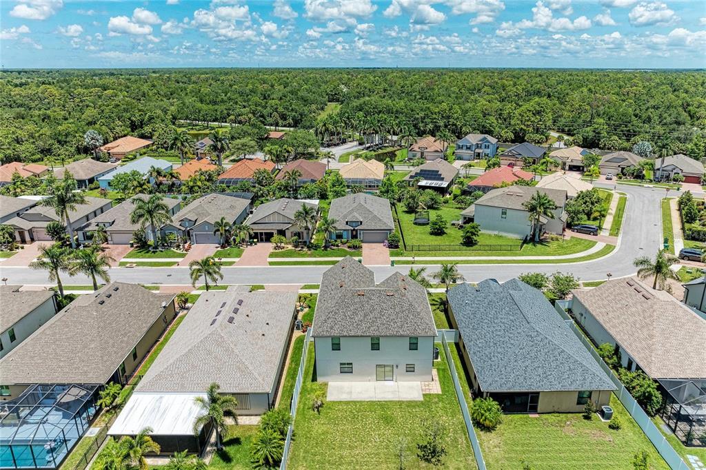 An aerial view shows a two-story house with a backyard lawn in a suburban neighborhood — 2084 LA PALMA AVENUE, PORT CHARLOTTE, FL