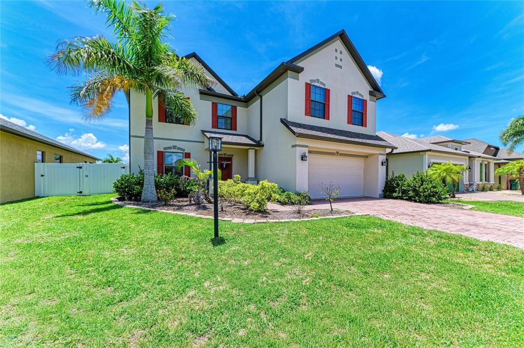 A two-story suburban house with a palm tree, red shutters, and a paved driveway — 2084 LA PALMA AVENUE, PORT CHARLOTTE, FL