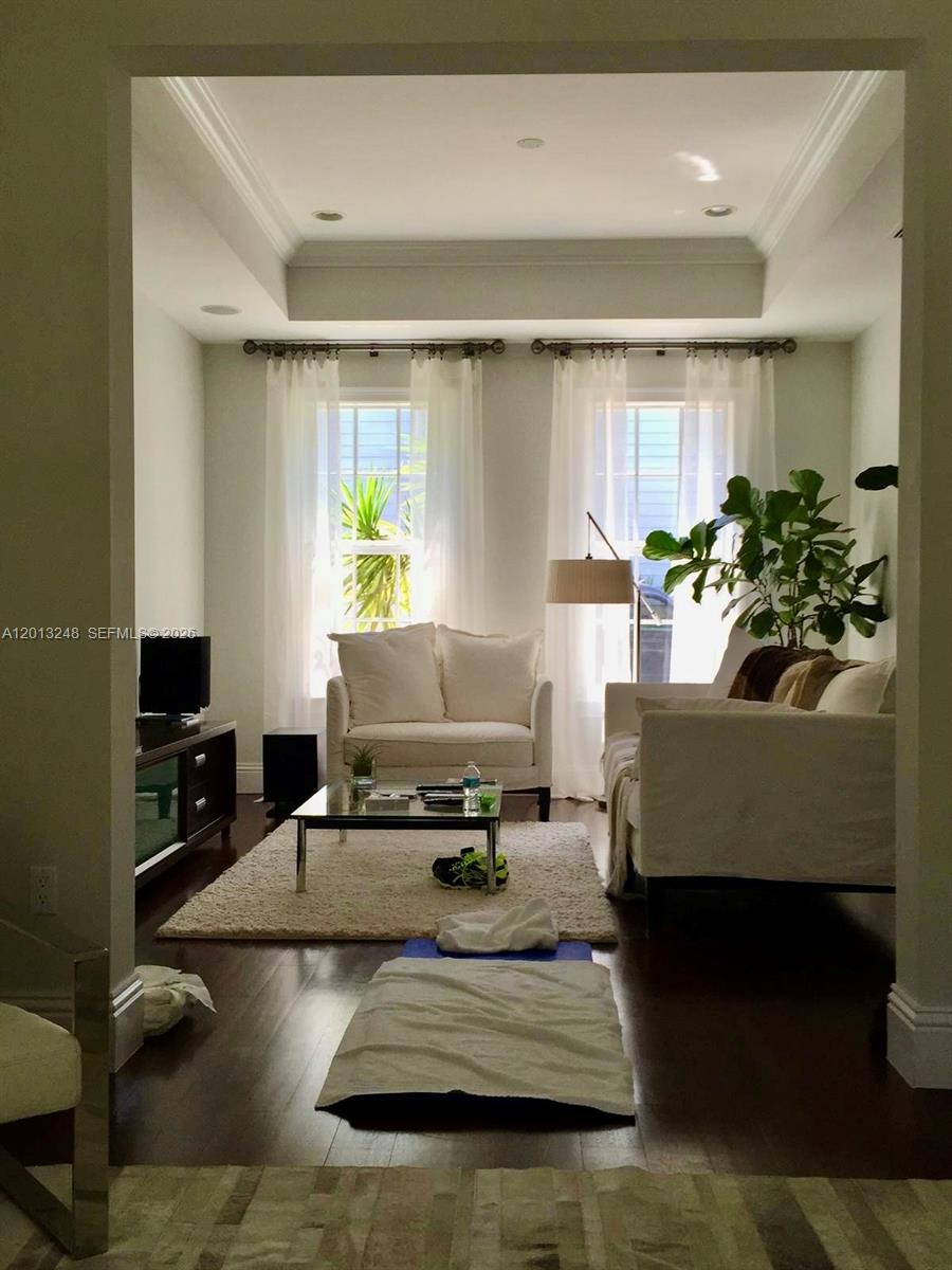 A living room with white furniture, a glass coffee table, and dark hardwood floors — 5000 SW 73rd Ter, Miami FL 33143, MIAMI, FL