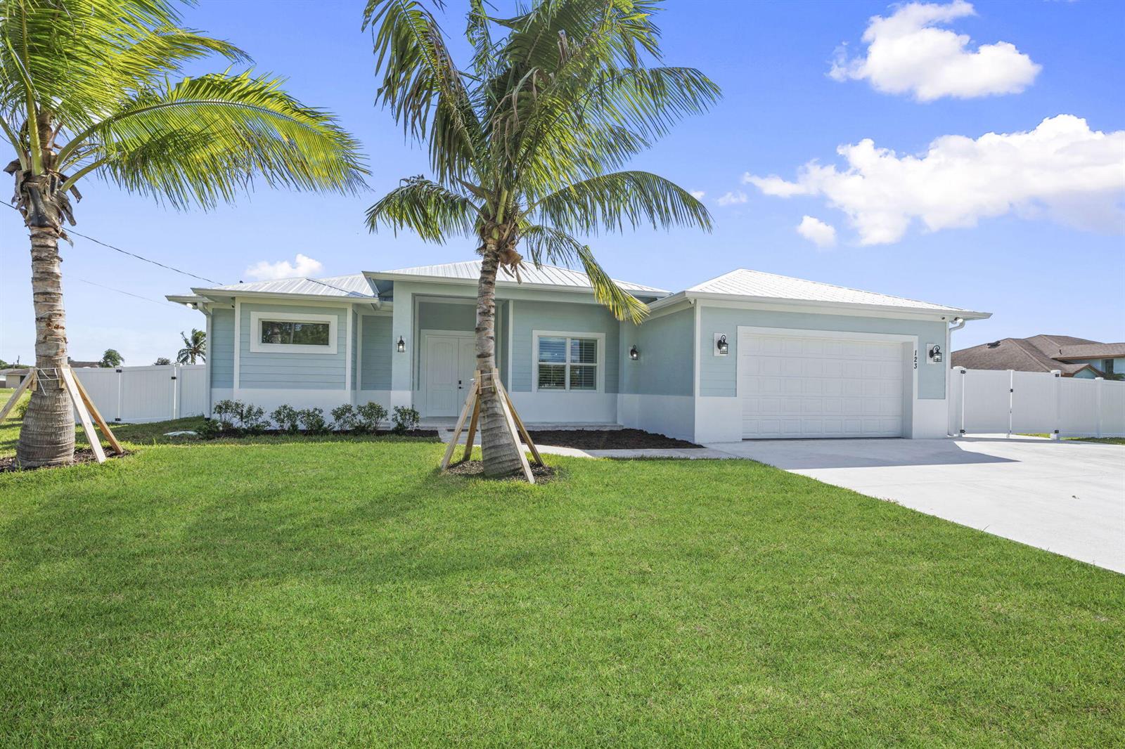 A light blue, single-story house with a white roof and a two-car garage — 3834 NE Barbara Drive, Jensen Beach FL 34957, JENSEN BEACH, FL