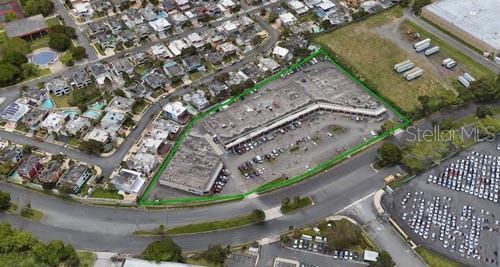 An aerial view shows a commercial shopping center with a parking lot and surrounding buildings — 1 BOULEVARD DE PALMAS, CATANO, PR