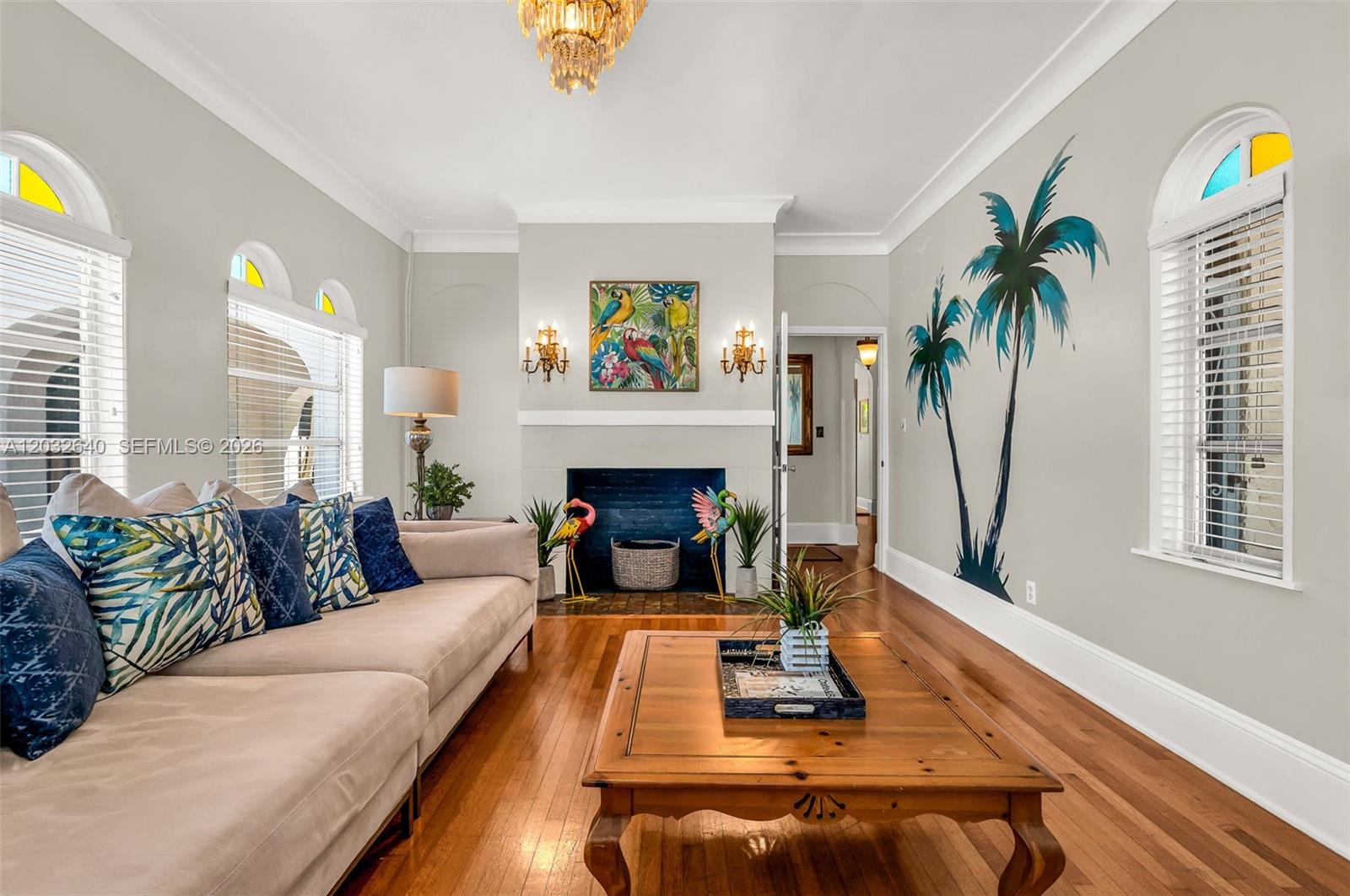 A living room features a beige sofa, a wooden coffee table, and palm tree wall art — 219 S 17th Ave S, Lake Worth FL 33460, LAKE WORTH, FL