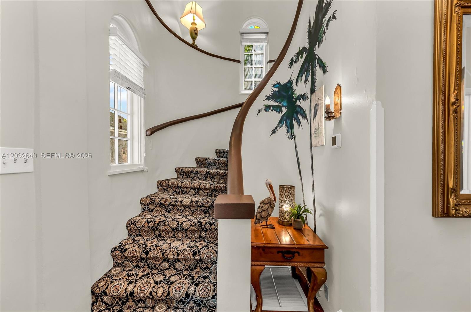 A carpeted staircase features a curved wooden handrail and a wall mural of palm trees — 219 S 17th Ave S, Lake Worth FL 33460, LAKE WORTH, FL