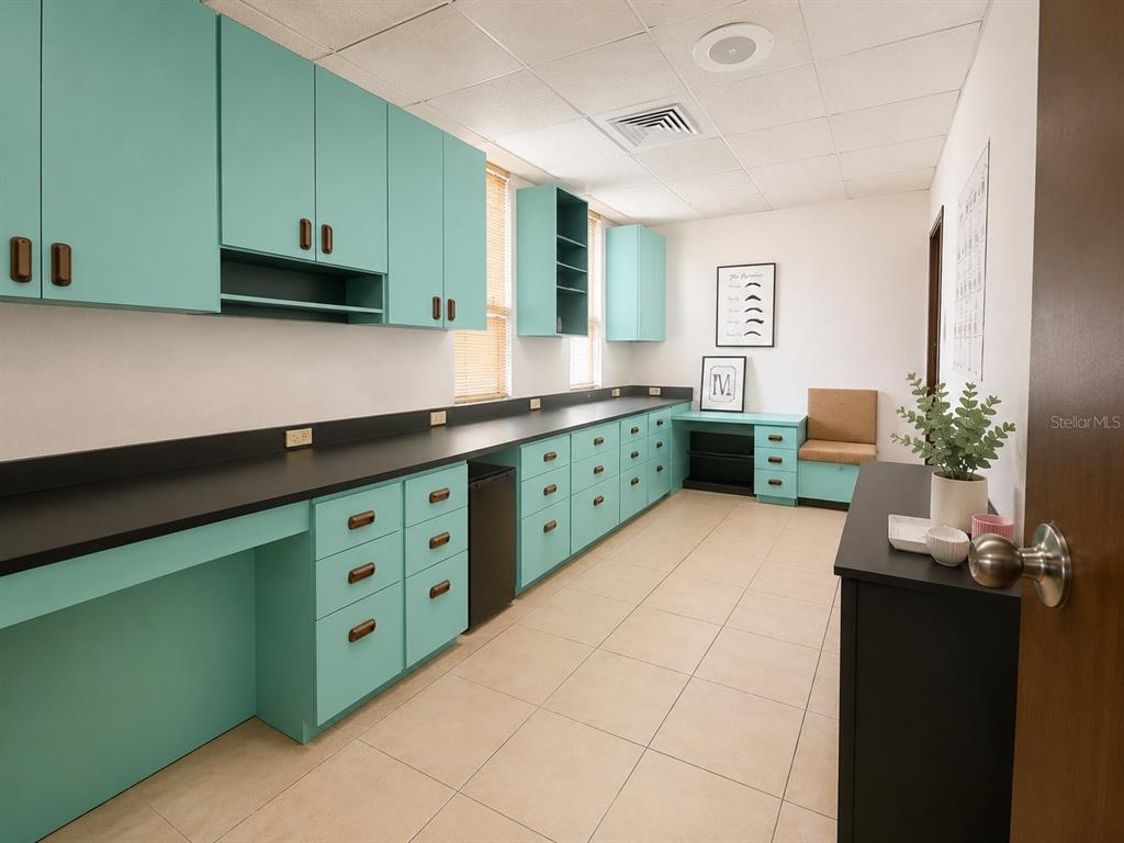 A bright office or workspace features teal cabinets, a long black countertop, and tiled flooring — 1716 SAN ALFONSO, SAN JUAN, PR