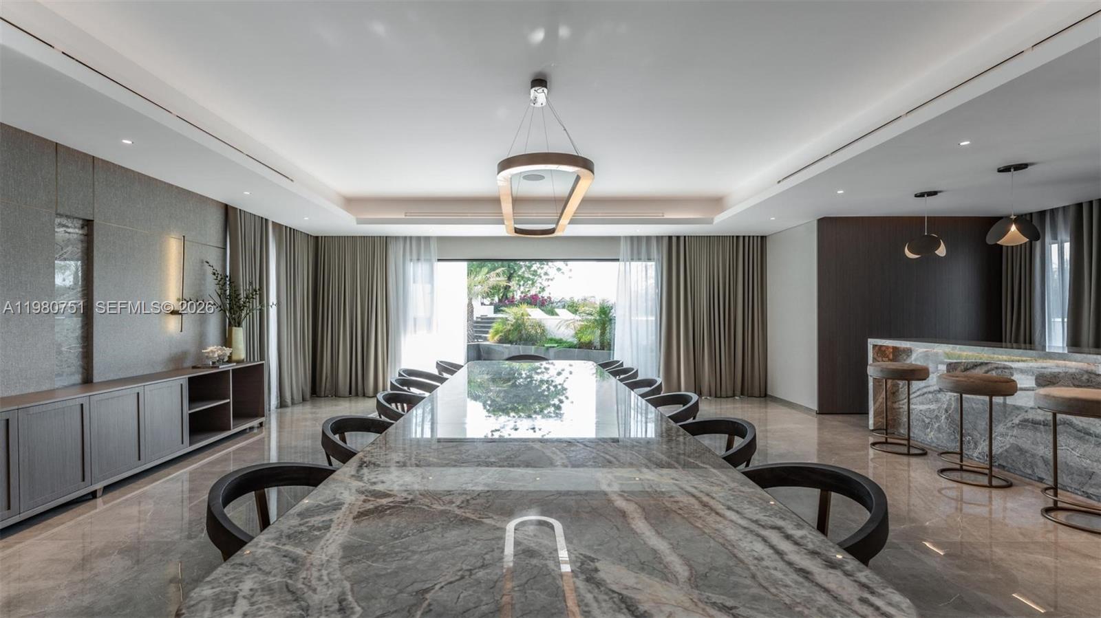 A dining room features a long marble table, dark chairs, and a marble-topped bar area — 15 Sector W Road, Dubai, FL