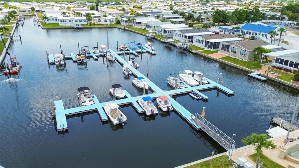 An aerial view shows a boat dock with multiple slips and vessels in a canal — 18 EMDEN CIRCLE, PUNTA GORDA, FL
