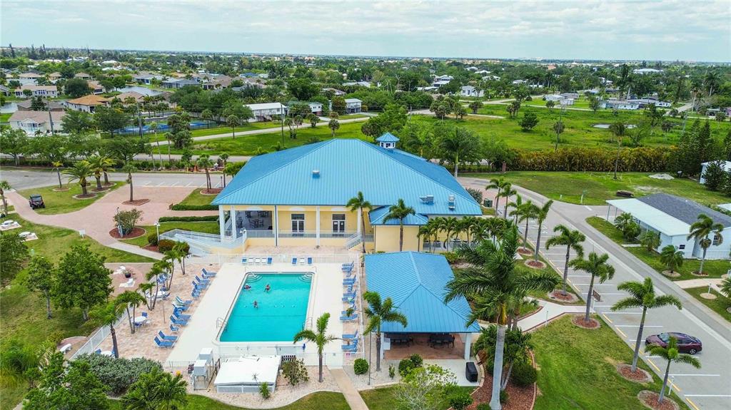 An aerial view of a community clubhouse with a swimming pool and surrounding palm trees — 18 EMDEN CIRCLE, PUNTA GORDA, FL