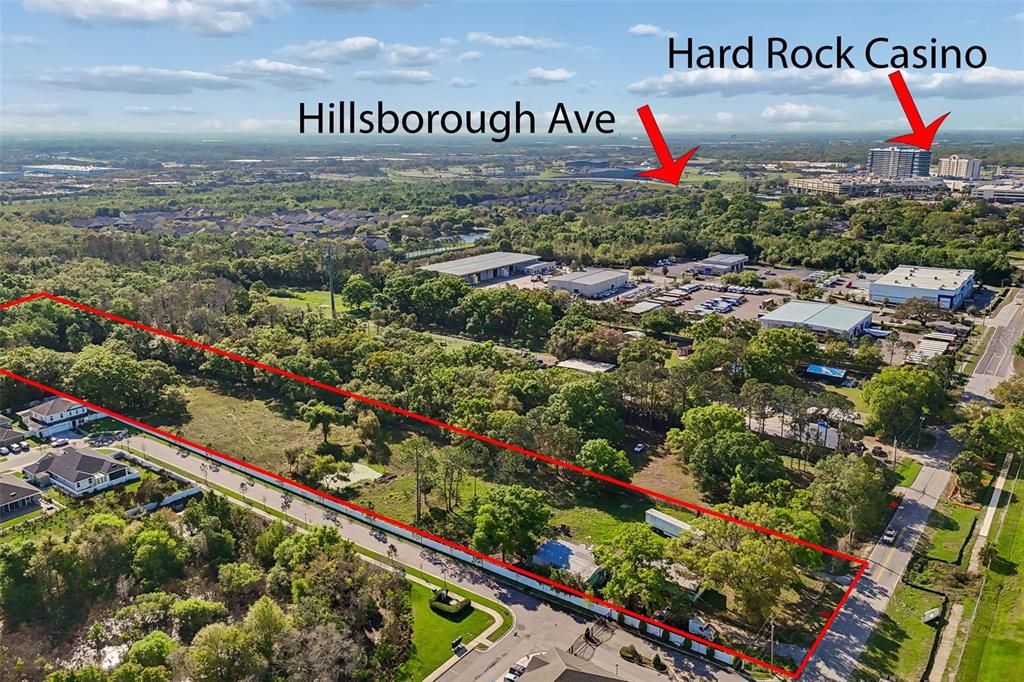 This aerial view shows a rectangular plot of land outlined in red near commercial buildings — 6213 ORIENT ROAD, TAMPA, FL