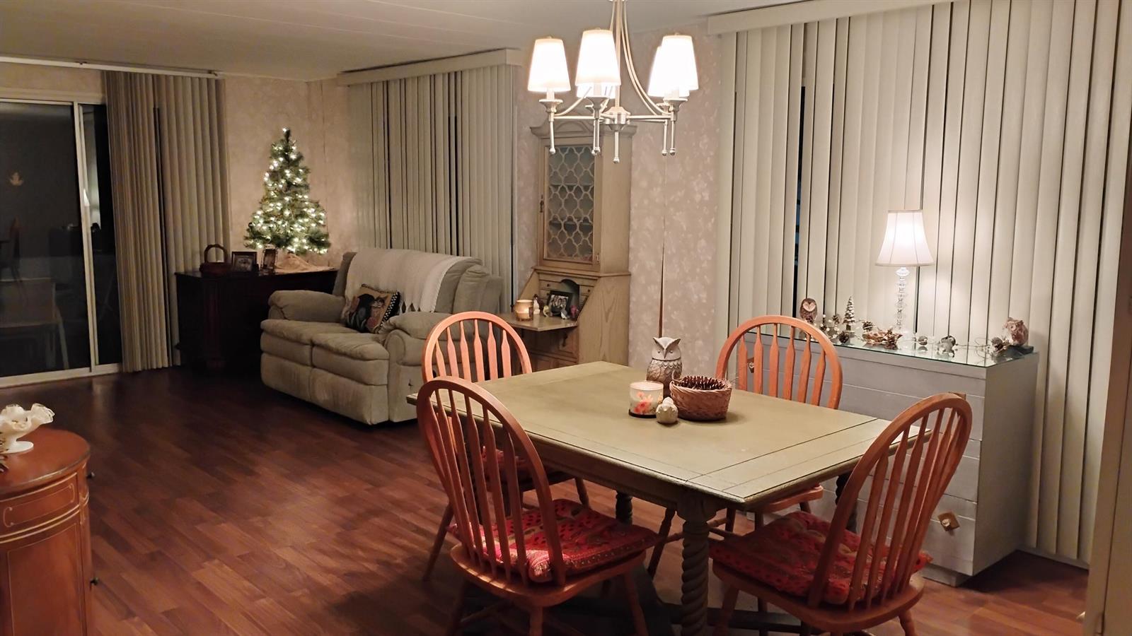 A dining area with a wooden table and chairs sits adjacent to a living room — 20911 Sunrise Drive, Boca Raton FL 33433, BOCA RATON, FL