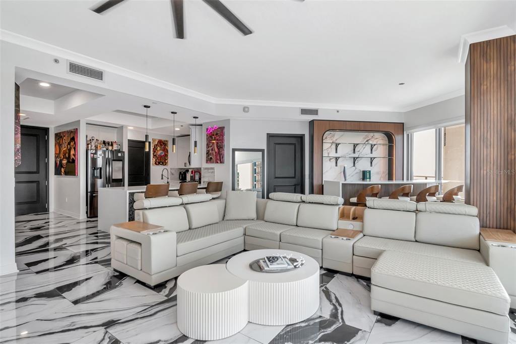 A modern living room features a large white sectional sofa, marble flooring, and a bar area — 1209 E CUMBERLAND AVENUE UNIT 1701, TAMPA, FL