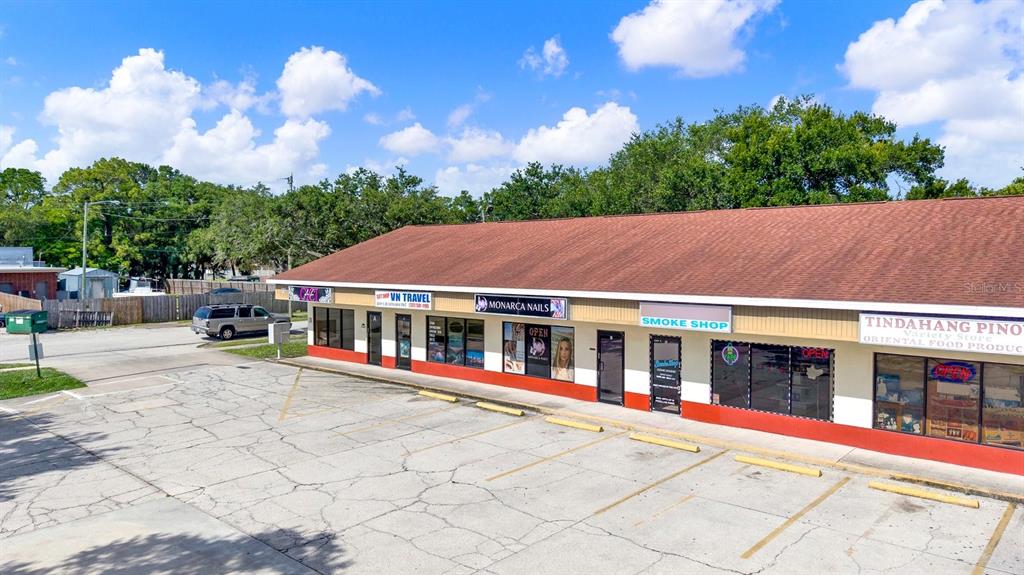 An exterior view of a single-story commercial strip mall with a parking lot — N 49TH, PINELLAS PARK, FL