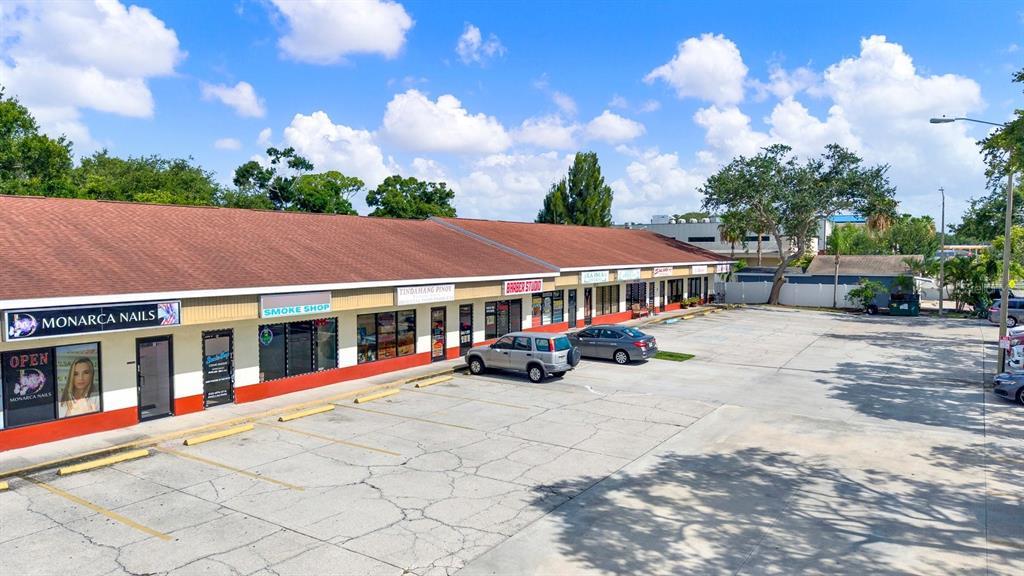 An exterior view of a single-story commercial strip mall with a parking lot in front — N 49TH, PINELLAS PARK, FL