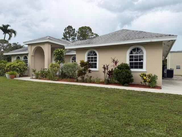 A single-story house with a beige stucco exterior, arched windows, and a covered entryway — 16304 Orange Boulevard, FL 33470, FL