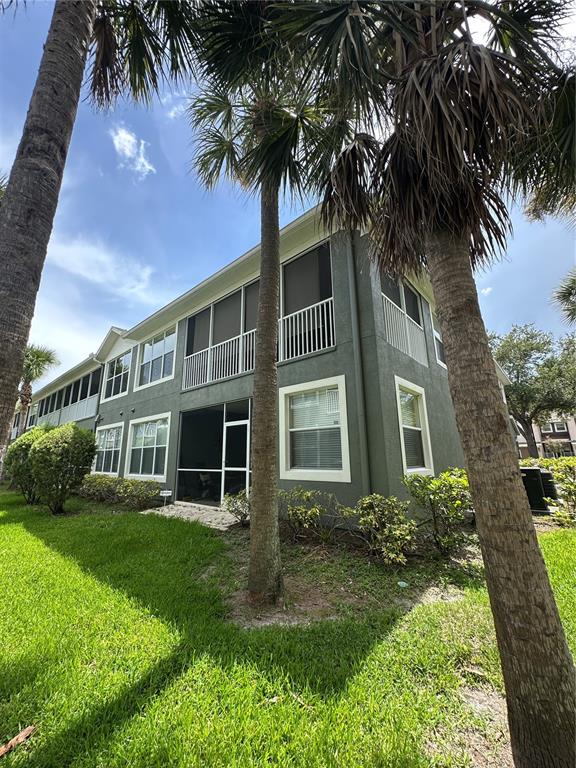 The exterior of a multi-story apartment building features screened-in balconies and palm trees — 2146 RIVER TURIA CIRCLE UNIT N/A, RIVERVIEW, FL
