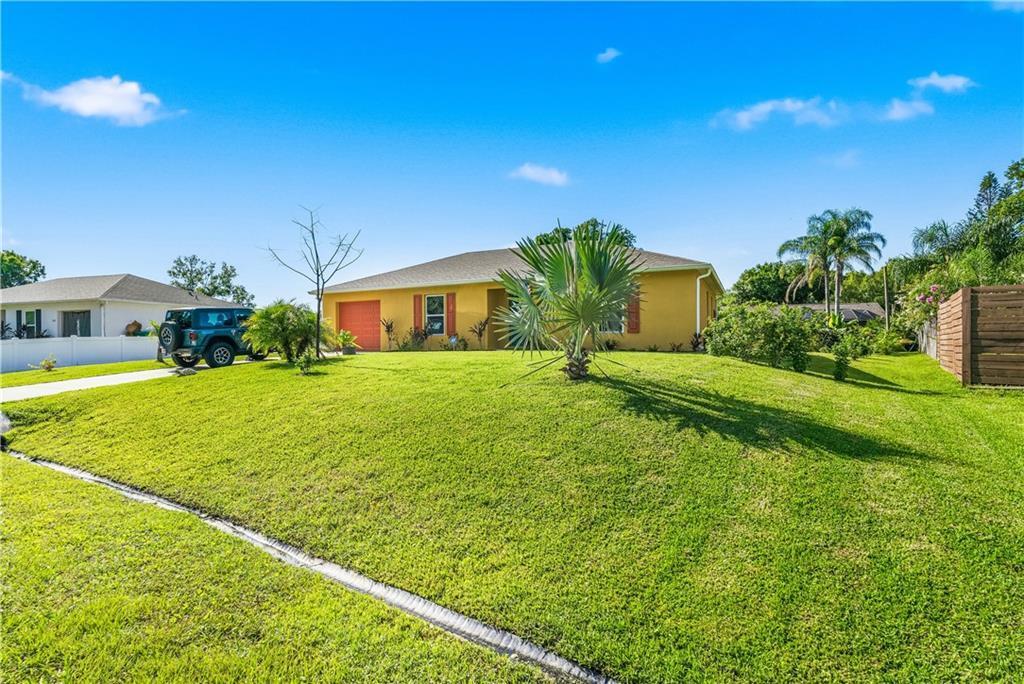 A yellow single-story house with a green lawn and a parked Jeep in the driveway — SEBASTIAN, FL