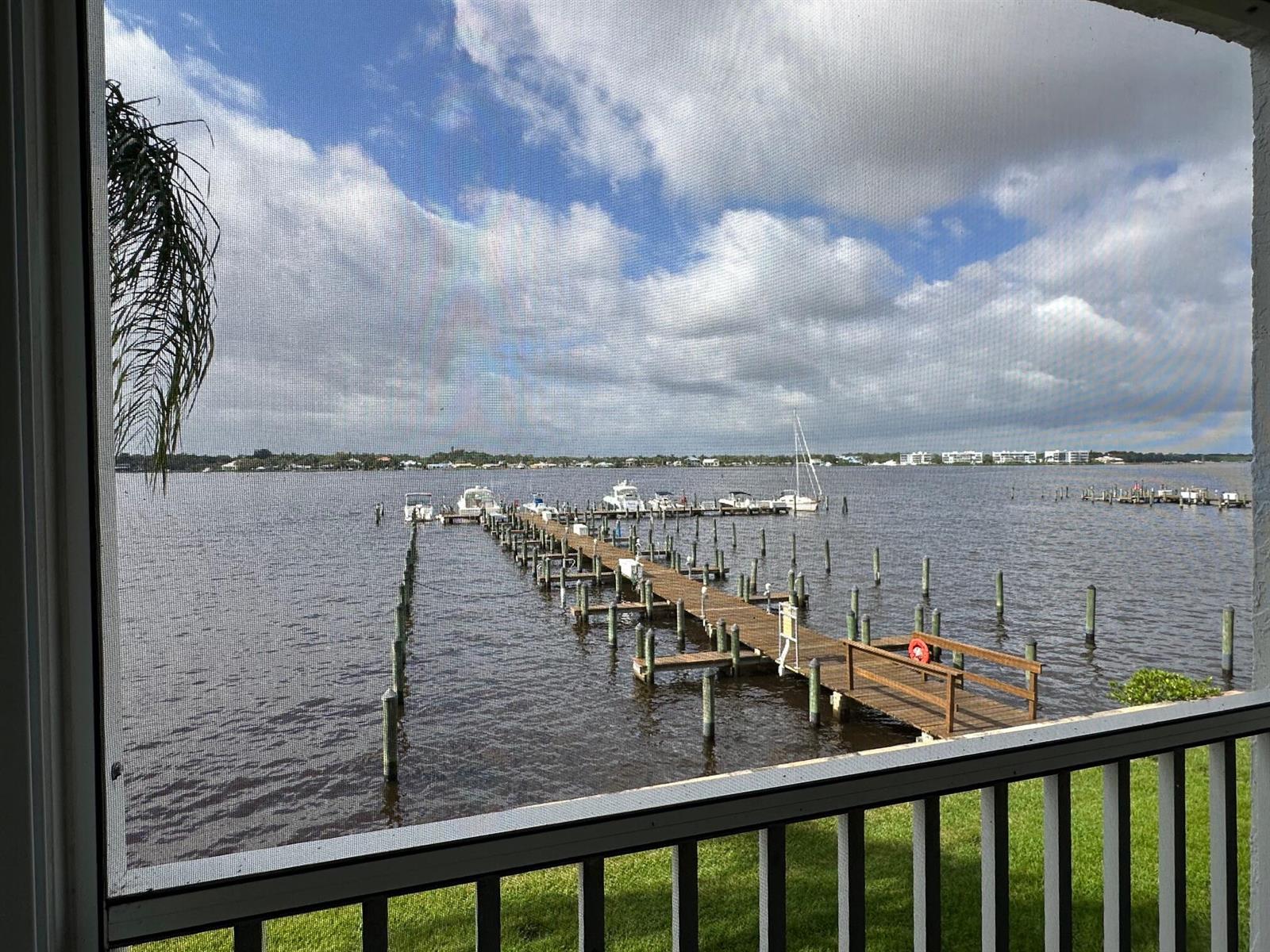 A view of a boat dock on a lake seen through a screened-in balcony — 1868 SW Palm City Road # 202, Stuart FL 34994, STUART, FL