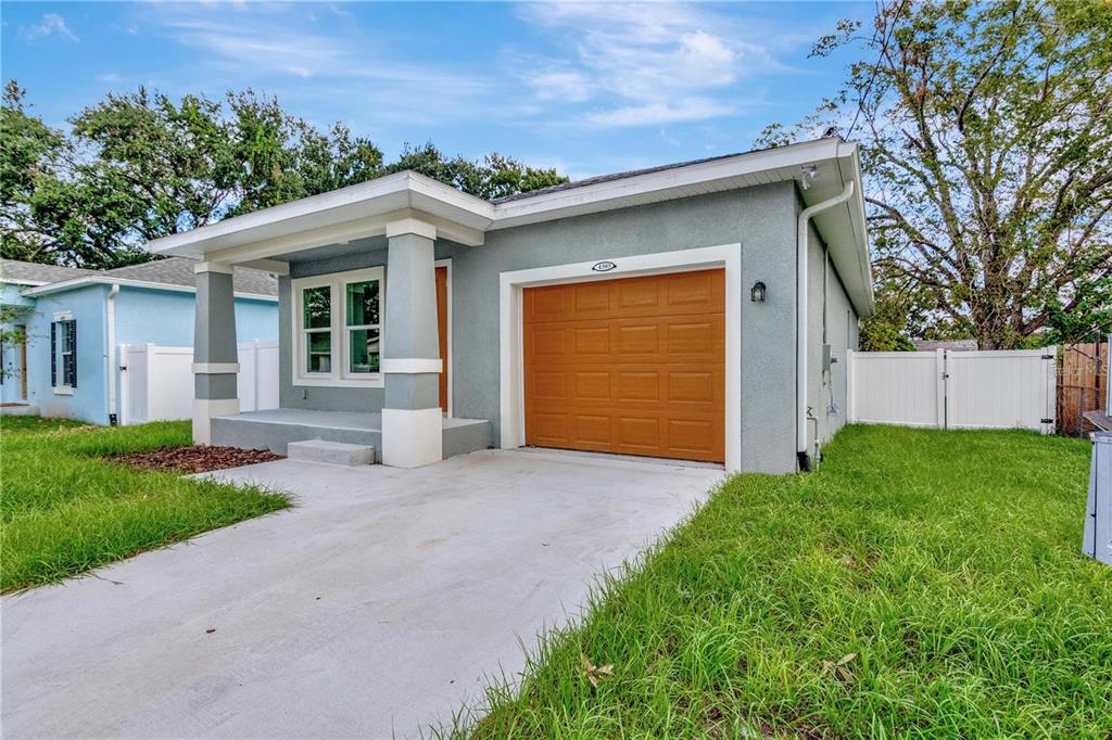 A gray single-story house with a front porch, a garage, and a concrete driveway — 4303 N 30TH STREET, TAMPA, FL