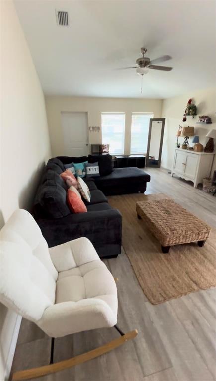 A living room features a dark sectional sofa, a white rocking chair, and a woven ottoman — 4303 N 30TH STREET, TAMPA, FL