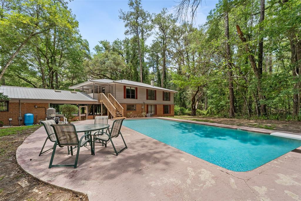 A two-story house with a backyard swimming pool and a patio set on a deck — 4703 NW 124TH STREET, GAINESVILLE, FL