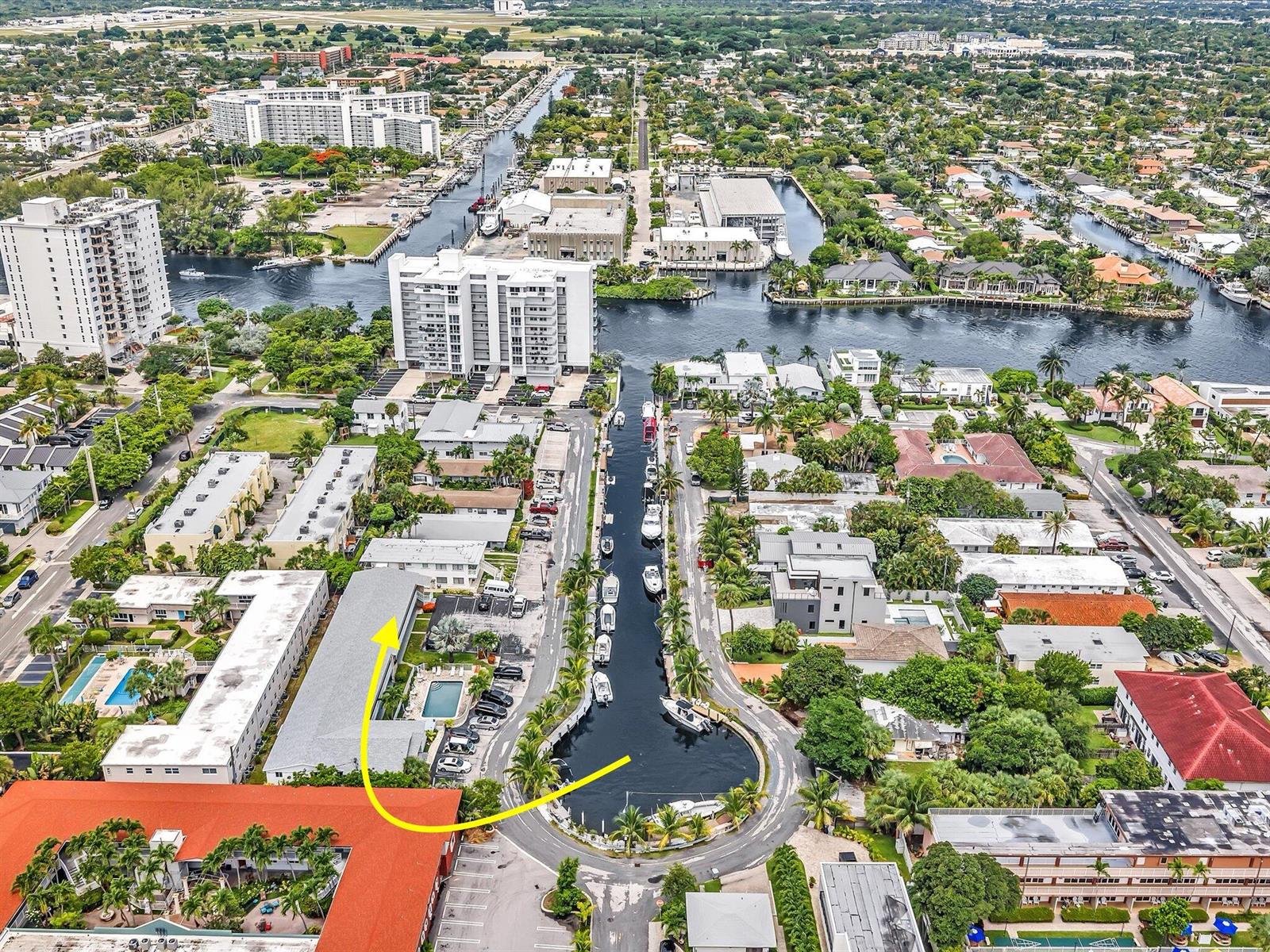 An aerial view shows a residential neighborhood with a canal, boat slips, and apartment buildings — 3232 Canal Drive # 19, Pompano Beach FL 33062, POMPANO BEACH, FL