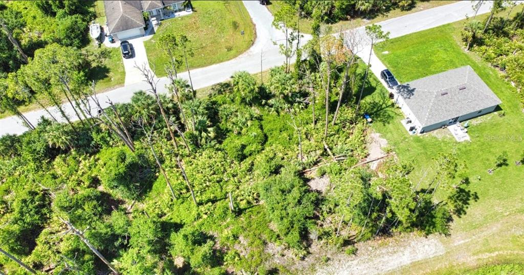 An aerial view shows a wooded vacant lot situated between two residential houses and streets — ARMENIA ROAD, NORTH PORT, FL