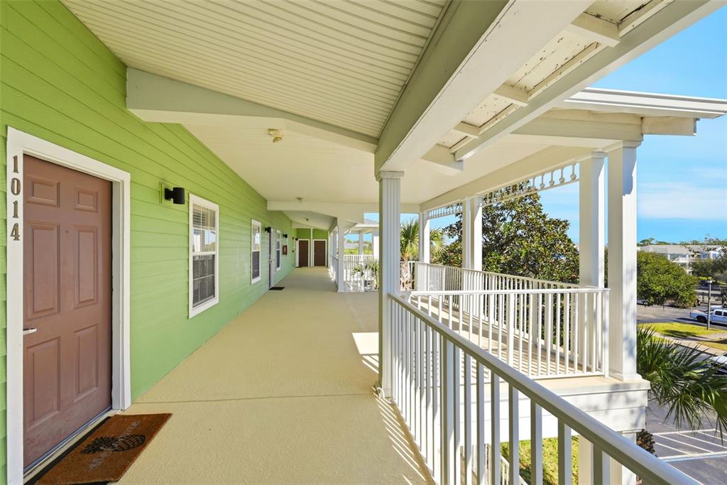 An outdoor covered walkway with light green siding, a brown door, and white railings — 1014 GRAN BAHAMA BOULEVARD UNIT 31-1014, DAVENPORT, FL