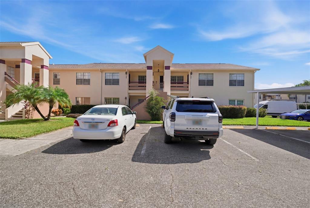 A two-story apartment building with a parking lot in the foreground — 7807 HARDWICK DRIVE UNIT 126, NEW PORT RICHEY, FL