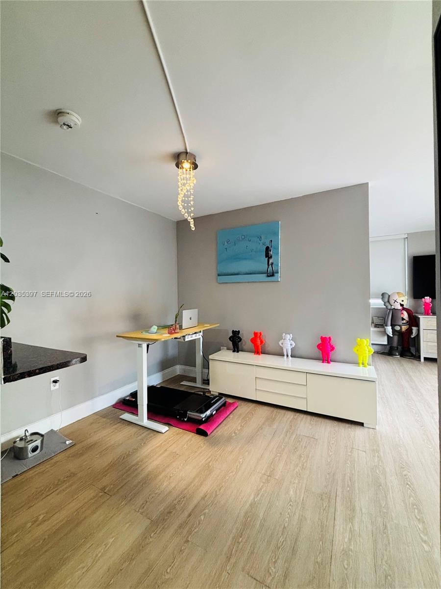 A room features a standing desk, a white media console, and several colorful collectible figurines — 1255 Collins Ave # 208, Miami Beach FL 33139, MIAMI BEACH, FL