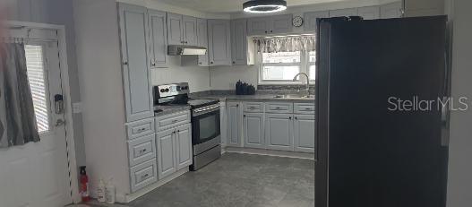 A white mobile home features a carport, two entry doors, and a brick-patterned base — 313 DANUBE CIRCLE, BRADENTON, FL