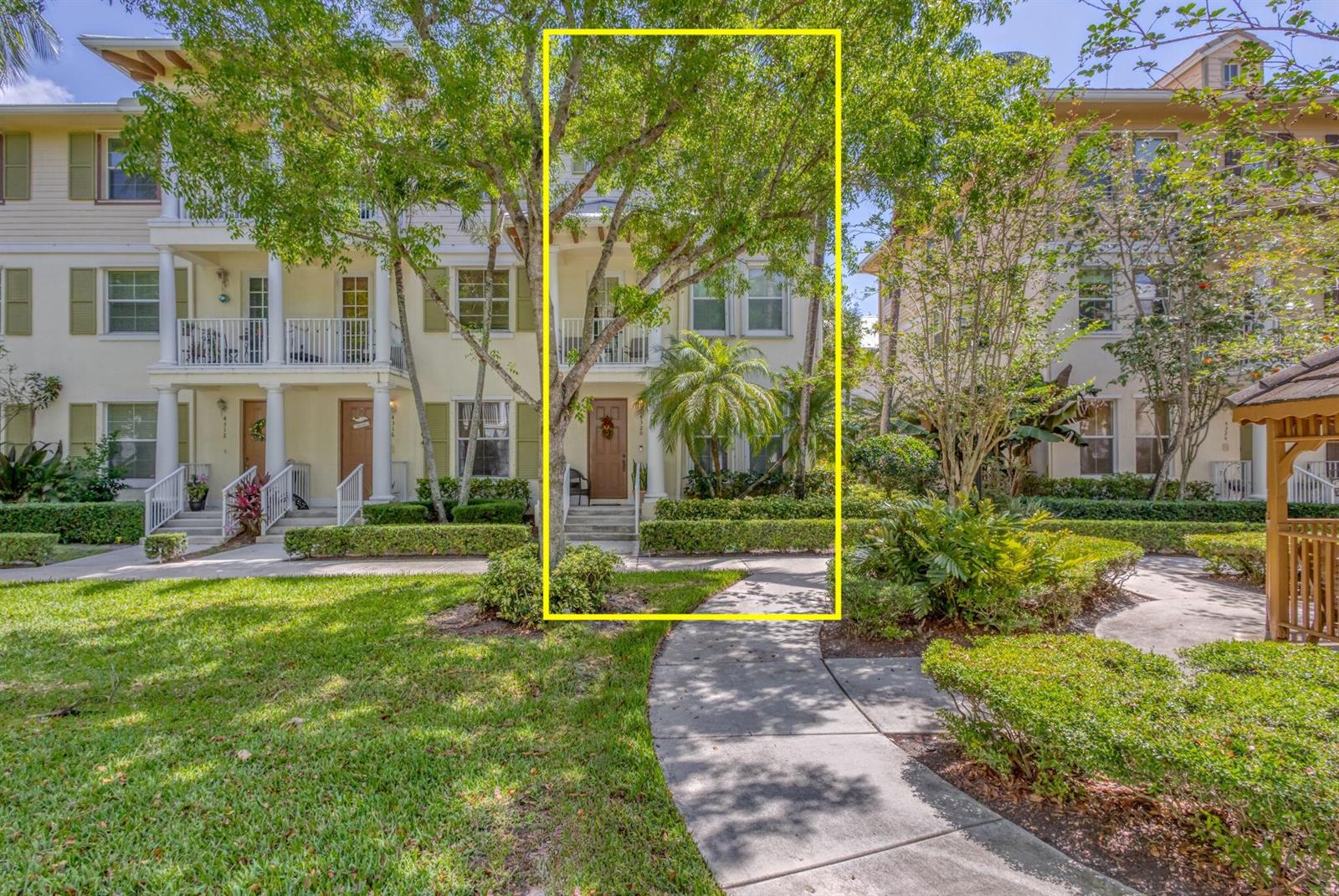 A three-story townhouse exterior with a brown front door, a balcony, and a front walkway — 4320 Blowing Point Place, Jupiter FL 33458, JUPITER, FL