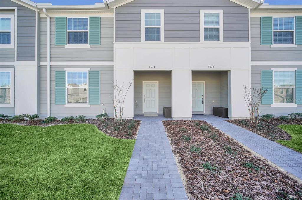 A two-story duplex building features gray siding, teal shutters, and two separate front entrances — 4034 LANA AVENUE, DAVENPORT, FL
