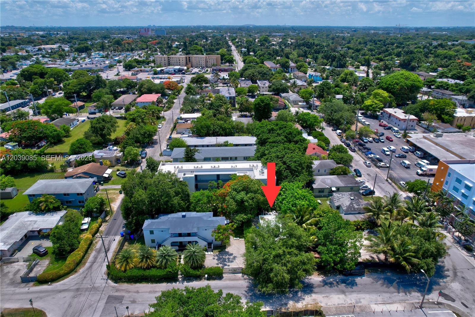 An aerial view shows a residential property marked by a red arrow among trees — 8280 NE 1st Pl, Miami FL 33138, MIAMI, FL