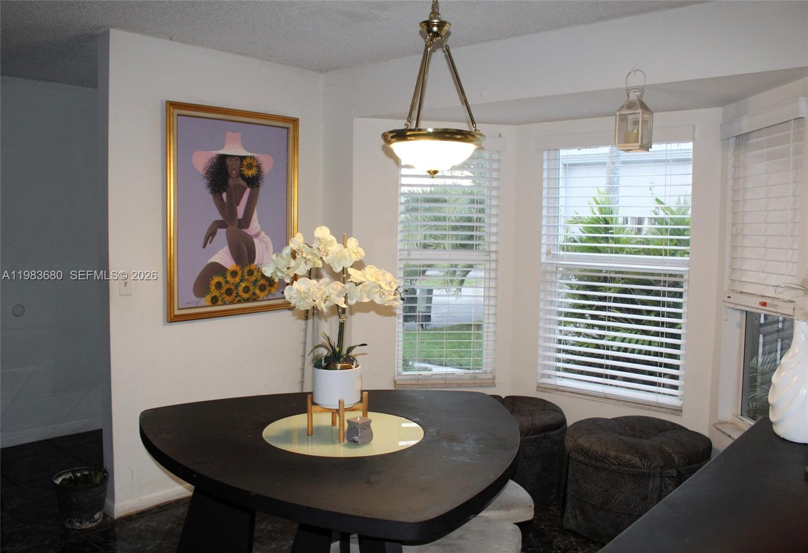 A dining area features a triangular table, a floral centerpiece, and a framed wall painting — 9818 SW 222nd Ter, Cutler Bay FL 33190, CUTLER BAY, FL