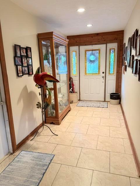 A tiled entryway features a wooden display cabinet, a decorative bird statue, and a front door — 9219 Nickels, Boynton Beach FL 33436, BOYNTON BEACH, FL
