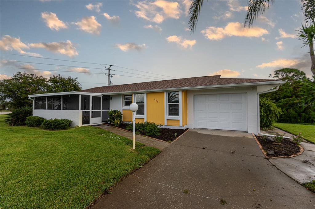 A single-story house with a yellow facade, a white garage door, and a screened porch — 295 ANNAPOLIS LANE, ROTONDA WEST, FL